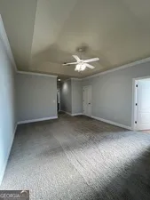 an empty room with a window and a fan