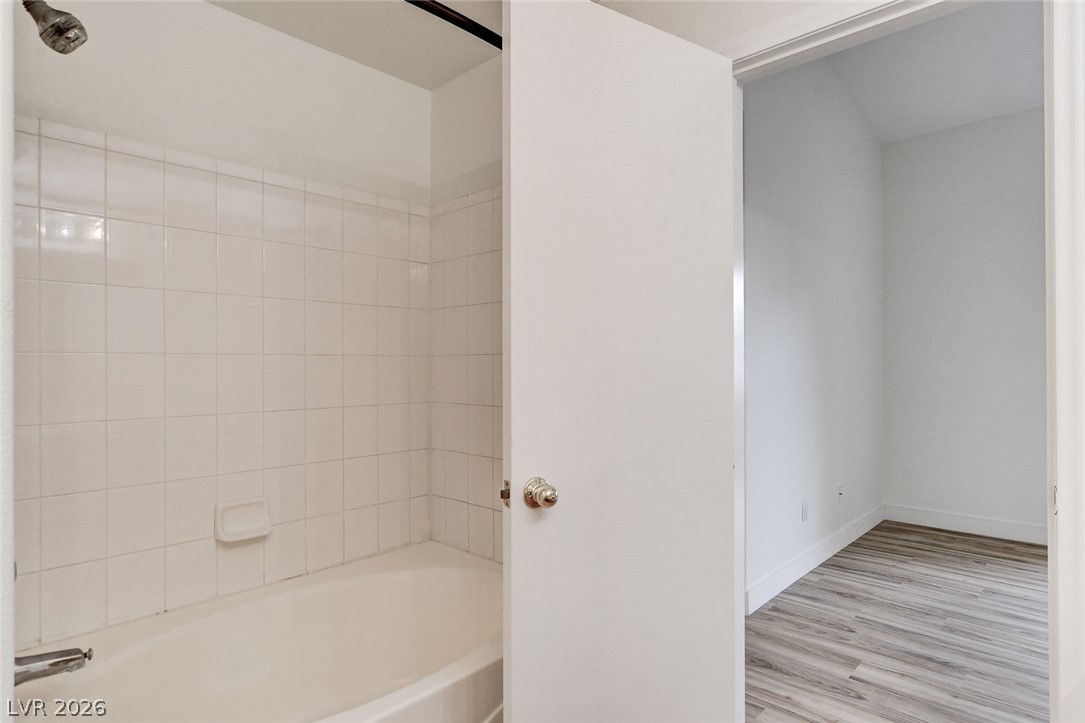2052 Quarry Ridge Street, Unit 201 Las Vegas, NV 89117 - Photo 20 of 25 A well-maintained tub with tiled surround offers a clean, inviting space for daily routines.