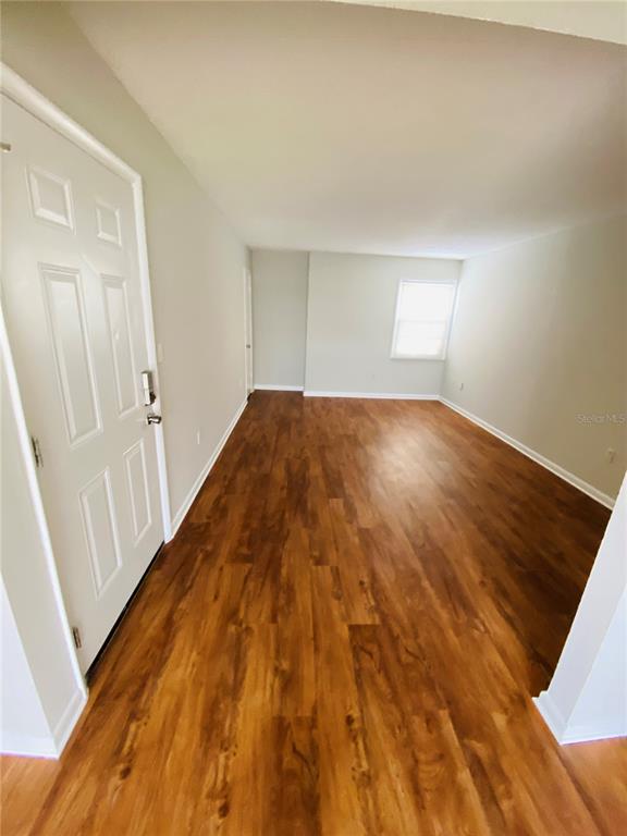 2757 L B McLeod Road, Unit C Orlando, FL 32805 - Photo 3 of 23 wooden floor in a hall with an empty room