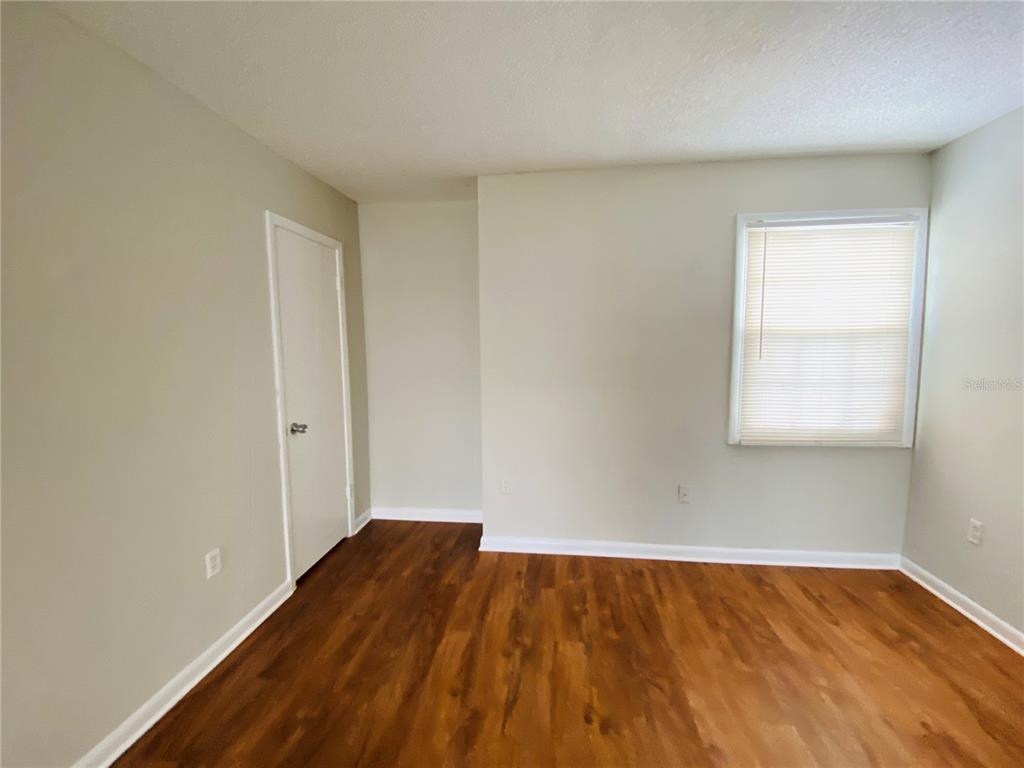 2757 L B McLeod Road, Unit C Orlando, FL 32805 - Photo 4 of 23 an empty room with wooden floor and windows