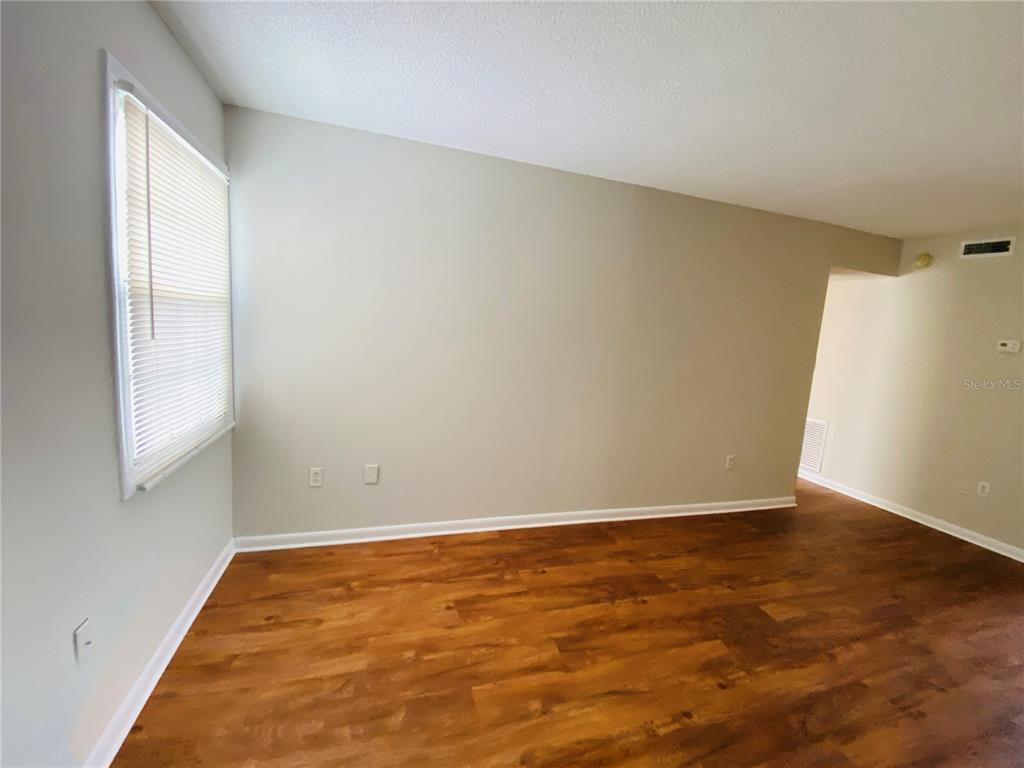 2757 L B McLeod Road, Unit C Orlando, FL 32805 - Photo 5 of 23 an empty room with wooden floor and windows