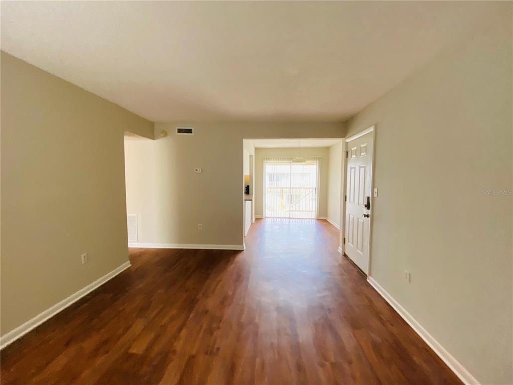 2757 L B McLeod Road, Unit C Orlando, FL 32805 - Photo 6 of 23 an empty room with wooden floor and windows