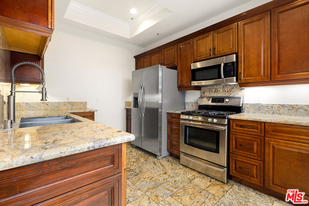 632 North Kings Road, Unit 201 West Hollywood, CA 90048 - Photo 3 of 14 a kitchen with stainless steel appliances granite countertop a stove microwave and refrigerator