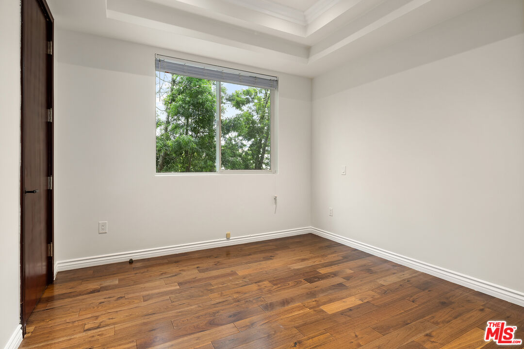 632 North Kings Road, Unit 201 West Hollywood, CA 90048 - Photo 5 of 14 an empty room with wooden floor and windows