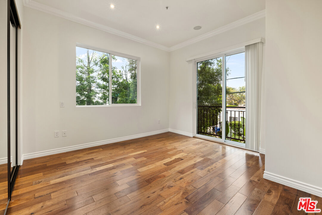 632 North Kings Road, Unit 201 West Hollywood, CA 90048 - Photo 7 of 14 a view of an empty room with wooden floor and a window