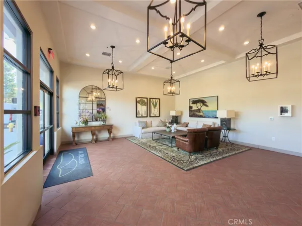 a living room with furniture a chandelier and a flat screen tv