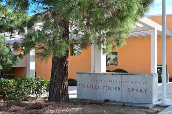 a sign board with a tree in front of it