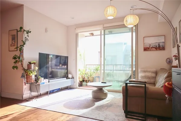 a living room with furniture a chandelier and a floor to ceiling window