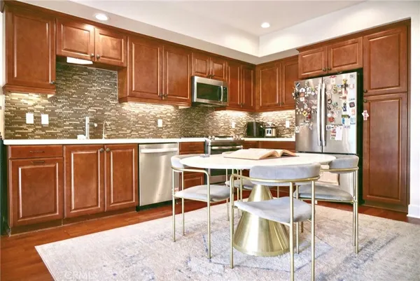 a kitchen with stainless steel appliances granite countertop a stove top oven a sink refrigerator and cabinets