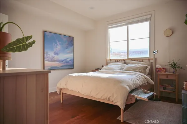 a bedroom with a bed a dresser and a window
