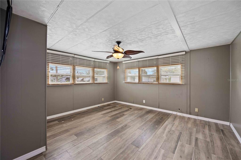 10303 Burnt Store Road, Unit 131 Punta Gorda, FL 33950 - Photo 11 of 25 a view of empty room with wooden floor and fan