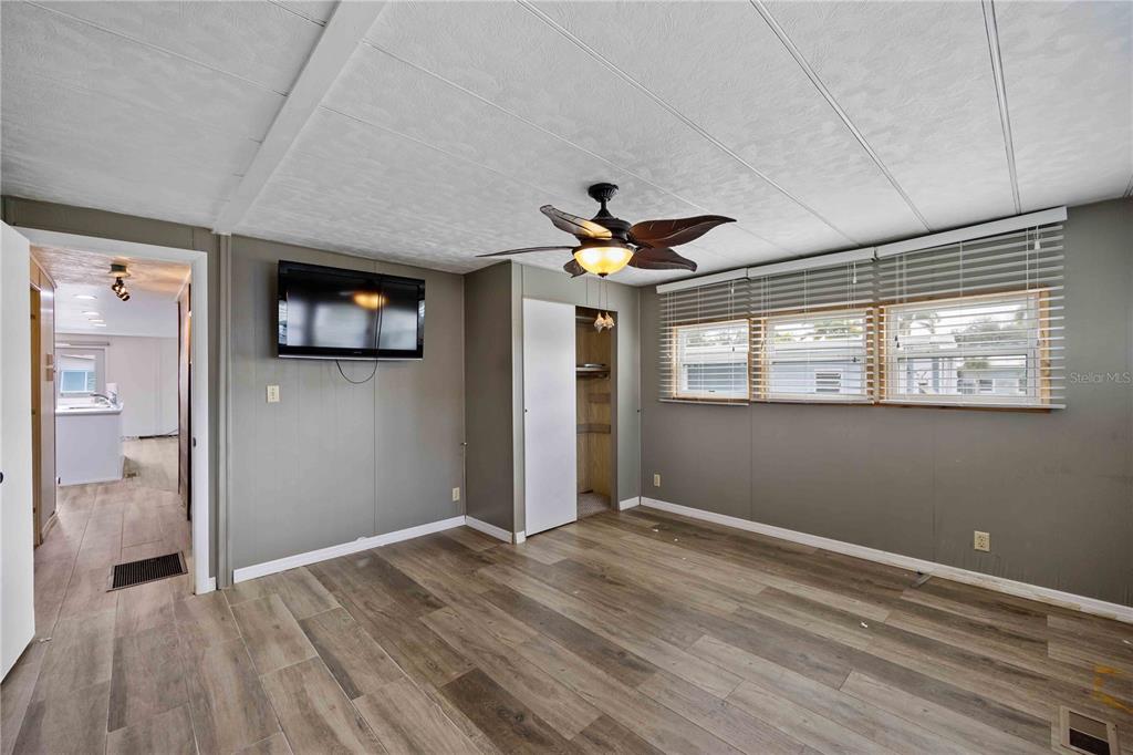 10303 Burnt Store Road, Unit 131 Punta Gorda, FL 33950 - Photo 12 of 25 a view of empty room with wooden floor and fan