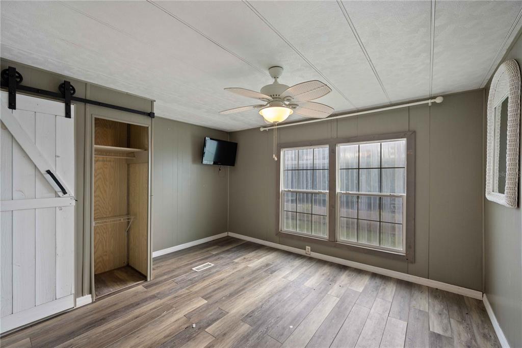 10303 Burnt Store Road, Unit 131 Punta Gorda, FL 33950 - Photo 9 of 25 an empty room with wooden floor and windows