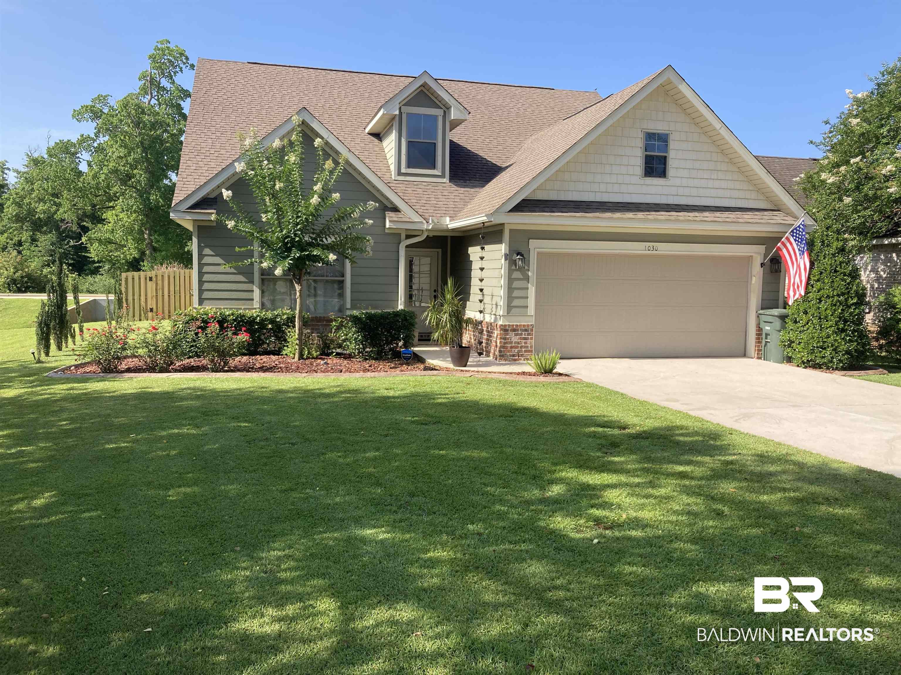 1030 Crown Walk Drive Foley, AL 36535 - Photo 1 of 40 View of front of property featuring concrete driveway, roof with shingles, a front yard, a garage, and brick siding