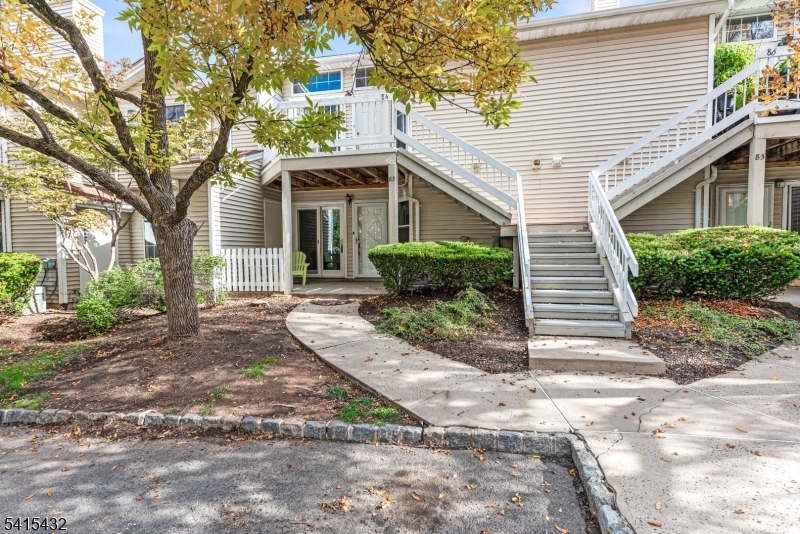 83 Mayfield Road, Unit 83 Bedminster, NJ 07921 - Photo 2 of 9 a front view of a house with a yard and potted plants
