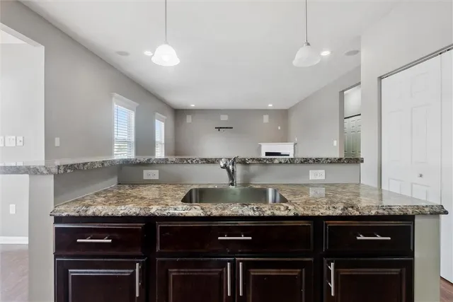 a kitchen with granite countertop a sink and cabinets