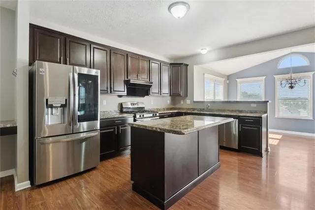 a kitchen with stainless steel appliances granite countertop a refrigerator stove and oven