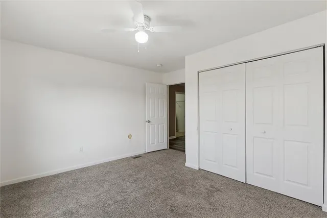 an empty room with a ceiling fan and a window