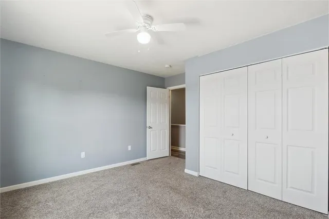 an empty room with a ceiling fan and a window