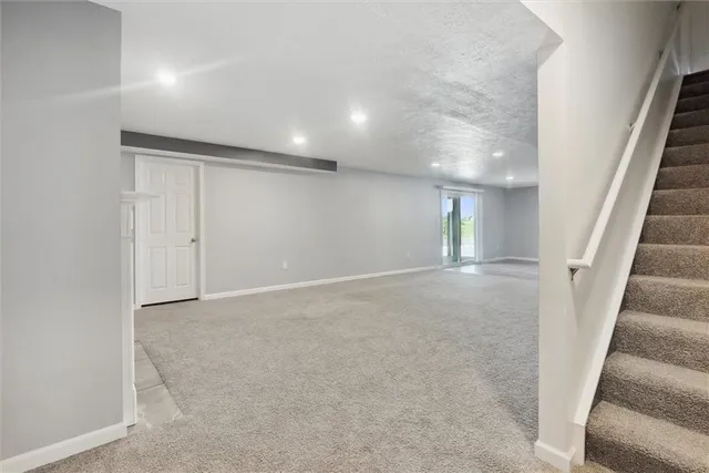 an empty room with staircase and white walls