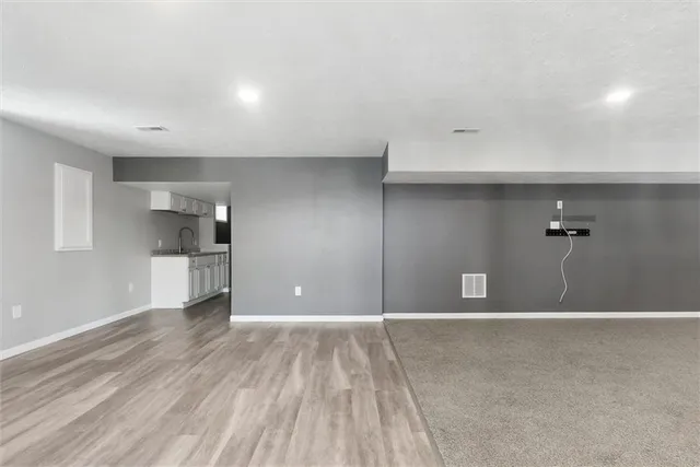 a view of a big room with wooden floor and windows