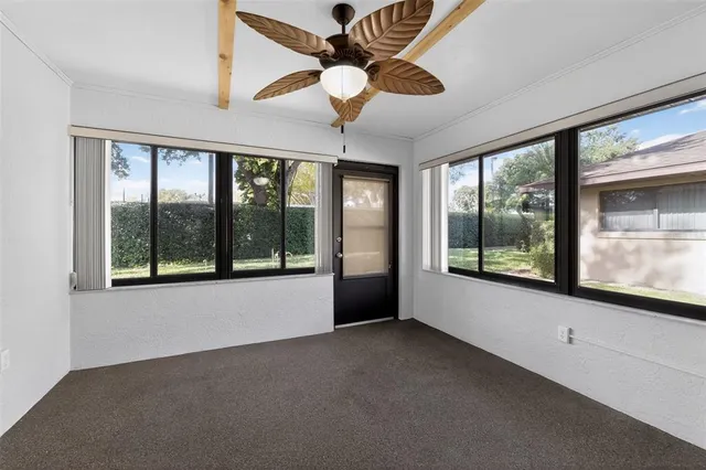 a view of an empty room with window chandelier fan