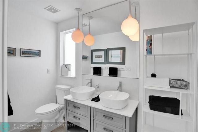 a bathroom with a sink a toilet and a mirror