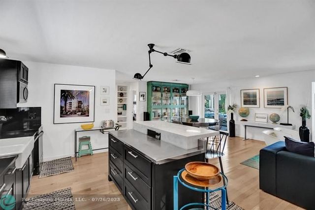 a living room with furniture a dining table and paintings on the wall