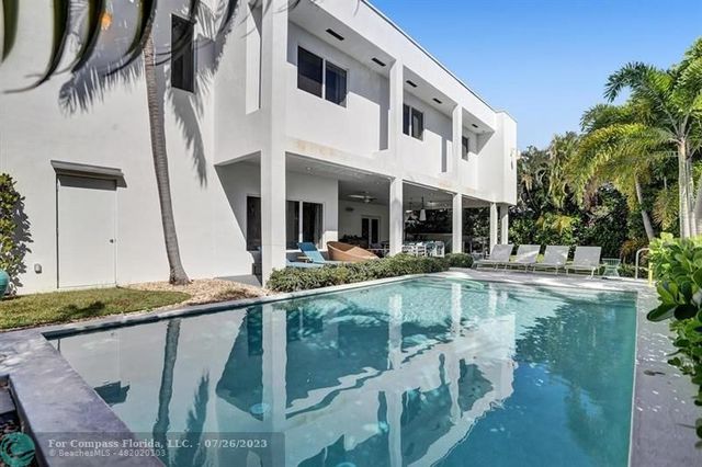 a view of a house with pool and chairs