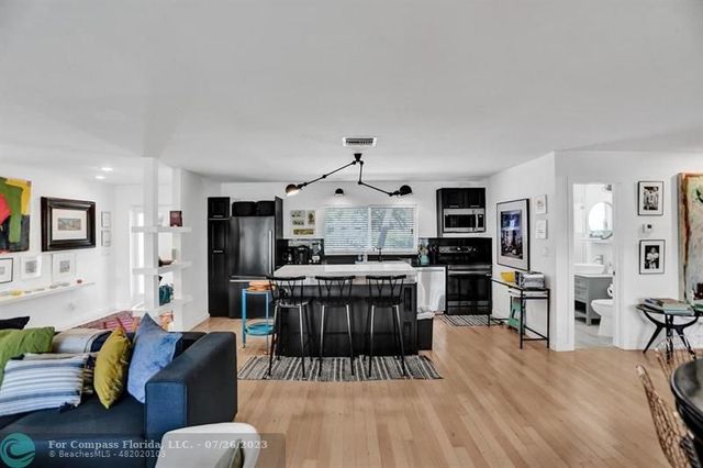 a living room with furniture a rug and kitchen view