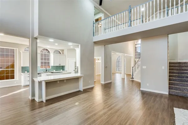 a view of an entryway and wooden floor and a kitchen