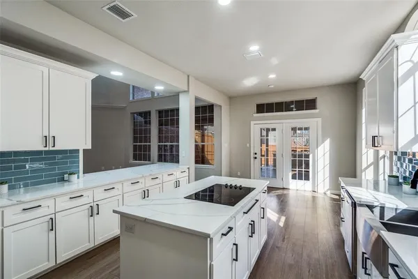 a kitchen with granite countertop a sink stove and cabinets