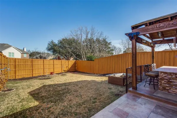 a backyard of a house with barbeque oven table and chairs