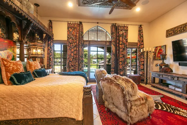 a bedroom with two beds and a flat tv screen next to a large window