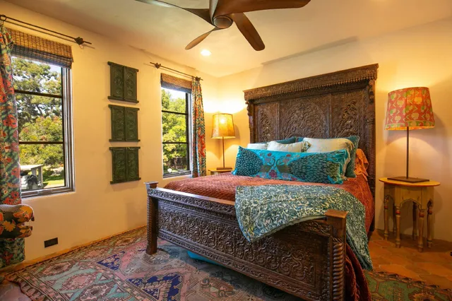 a bedroom with a bed a dresser next to a window