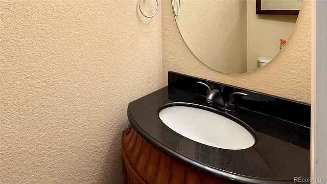 a bathroom with a sink mirror vanity and toilet