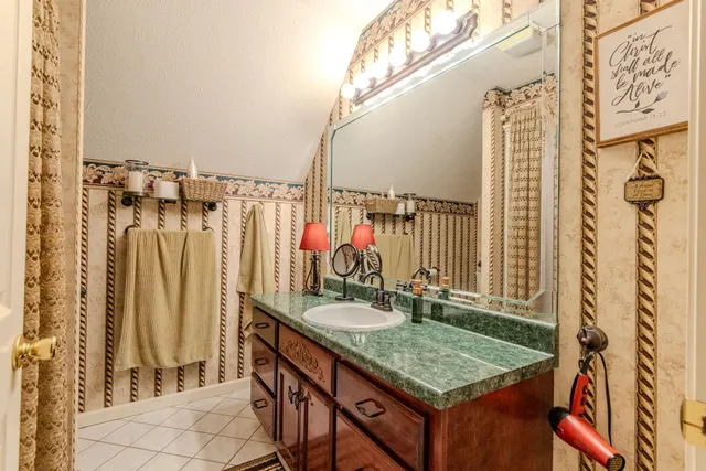 a bathroom with a granite countertop sink and a mirror