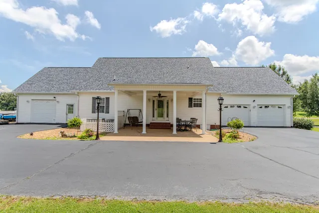 a view of a house with a patio and a yard