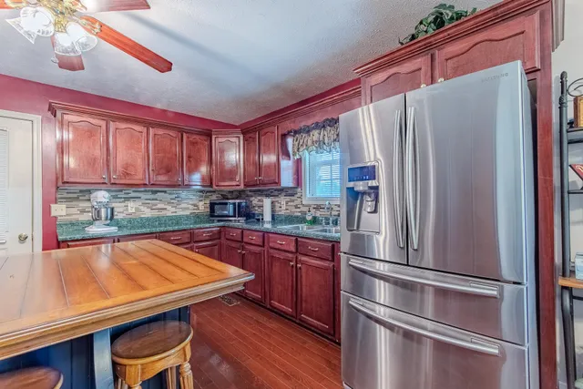 a kitchen with stainless steel appliances granite countertop a refrigerator and a stove top oven