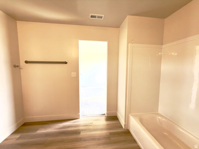1823 South Longview Road Santaquin, UT 84655 - Photo 51 of 69 Bathroom featuring a white bathtub and shower surround, wood-finish flooring, and a bronze-finish towel bar
