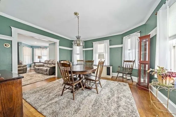 a view of a dining room and livingroom with furniture wooden floor a chandelier