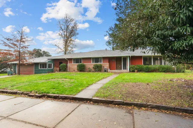 a front view of a house with a yard and potted plants