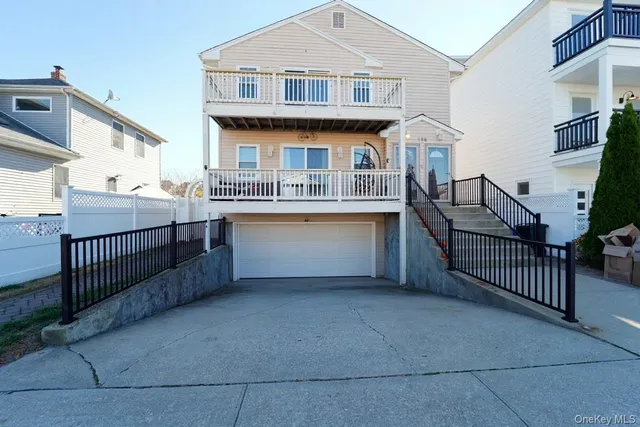 a view of a house with wooden fence and a porch