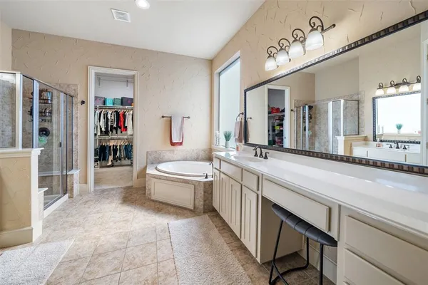 a spacious bathroom with a granite countertop sink a mirror and a bathtub
