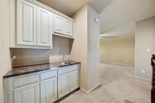 a kitchen with granite countertop white cabinets and a sink