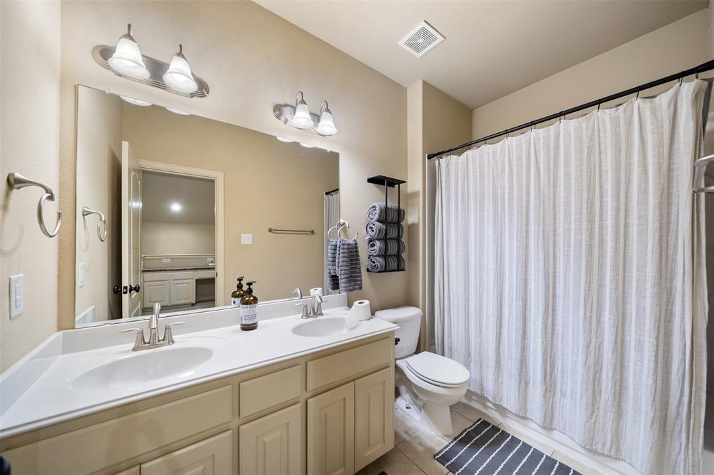 5048 Exposition Way Fort Worth, TX 76244 - Photo 34 of 39 a bathroom with a double vanity sink toilet and a mirror