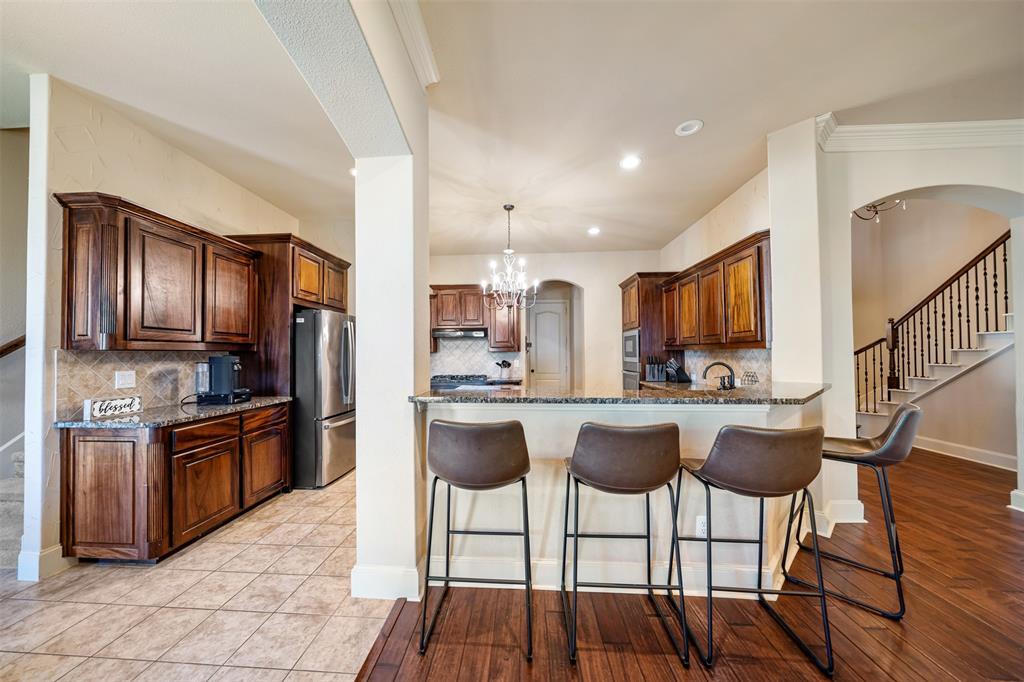 5048 Exposition Way Fort Worth, TX 76244 - Photo 7 of 39 a kitchen with stainless steel appliances granite countertop a stove top oven a refrigerator a sink and chairs