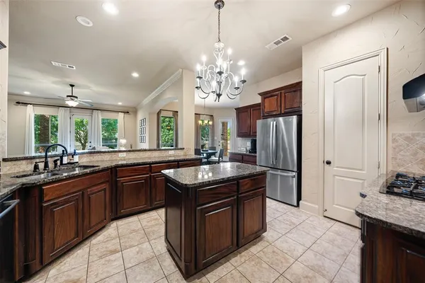 a kitchen with granite countertop a sink stove and refrigerator
