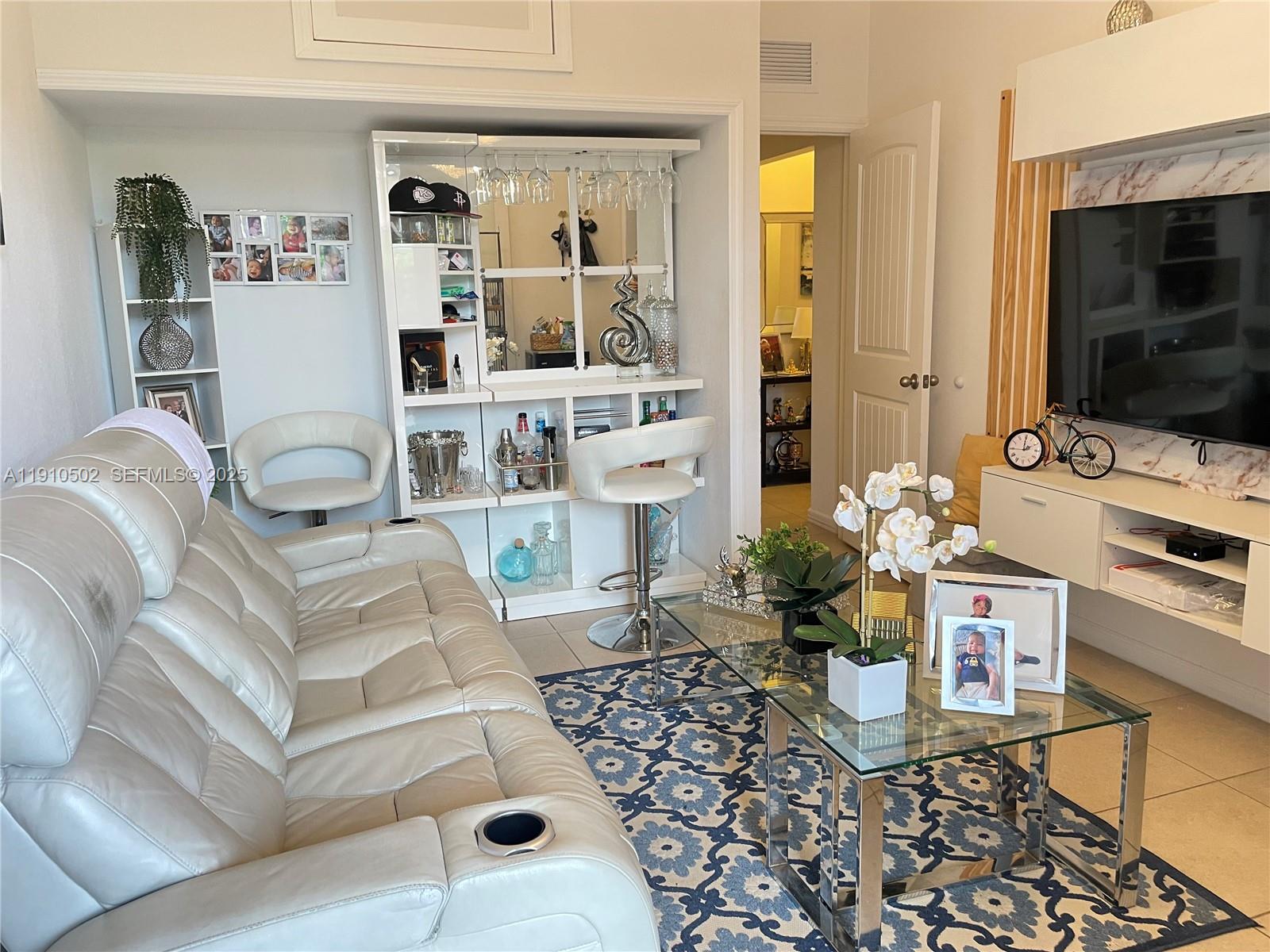 27563 Southwest 139th Place, Unit B Homestead, FL 33032 - Photo 3 of 17 a living room with furniture and a flat screen tv