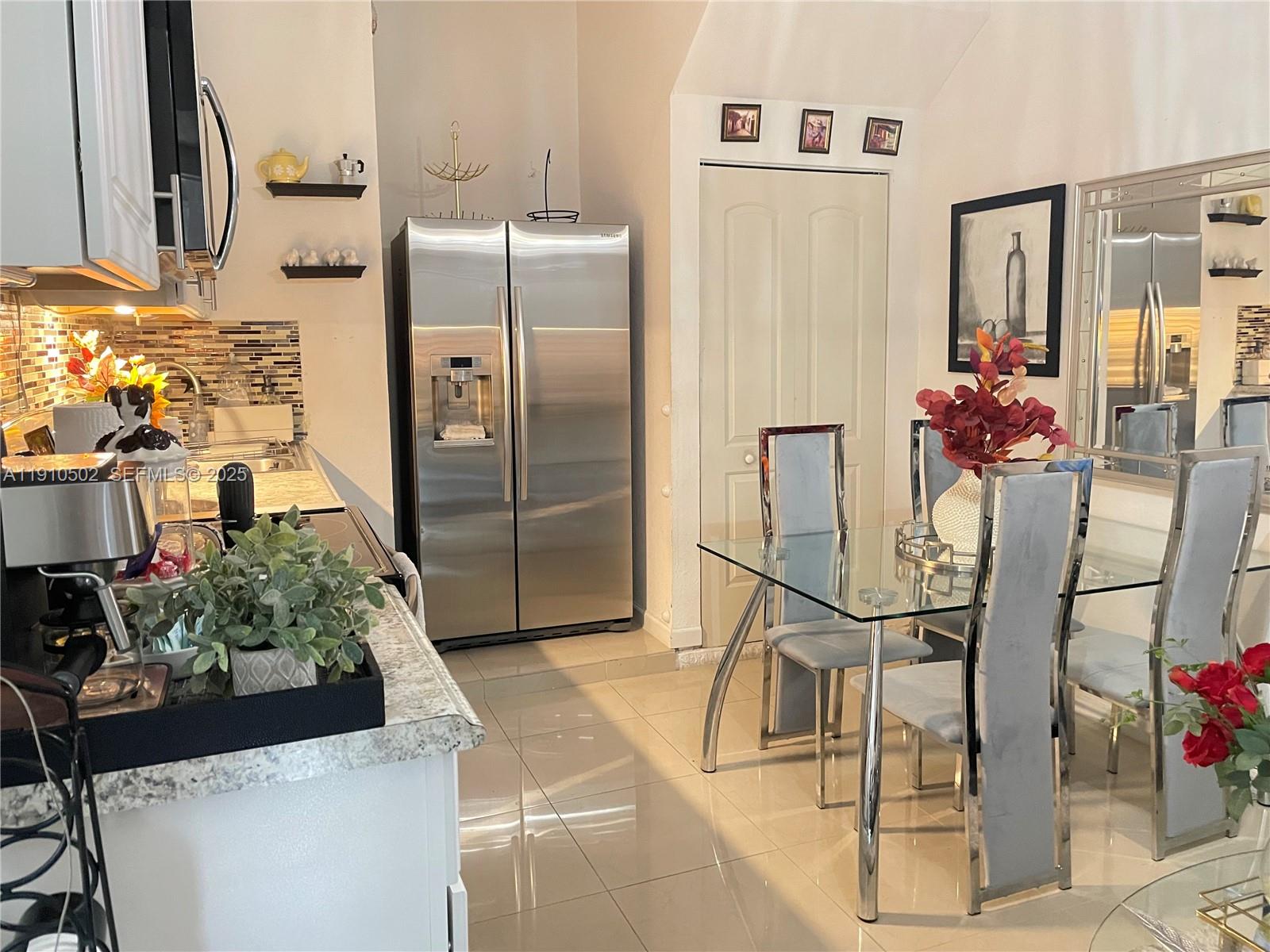 27563 Southwest 139th Place, Unit B Homestead, FL 33032 - Photo 5 of 17 a kitchen with stainless steel appliances kitchen island granite countertop cabinets and refrigerator